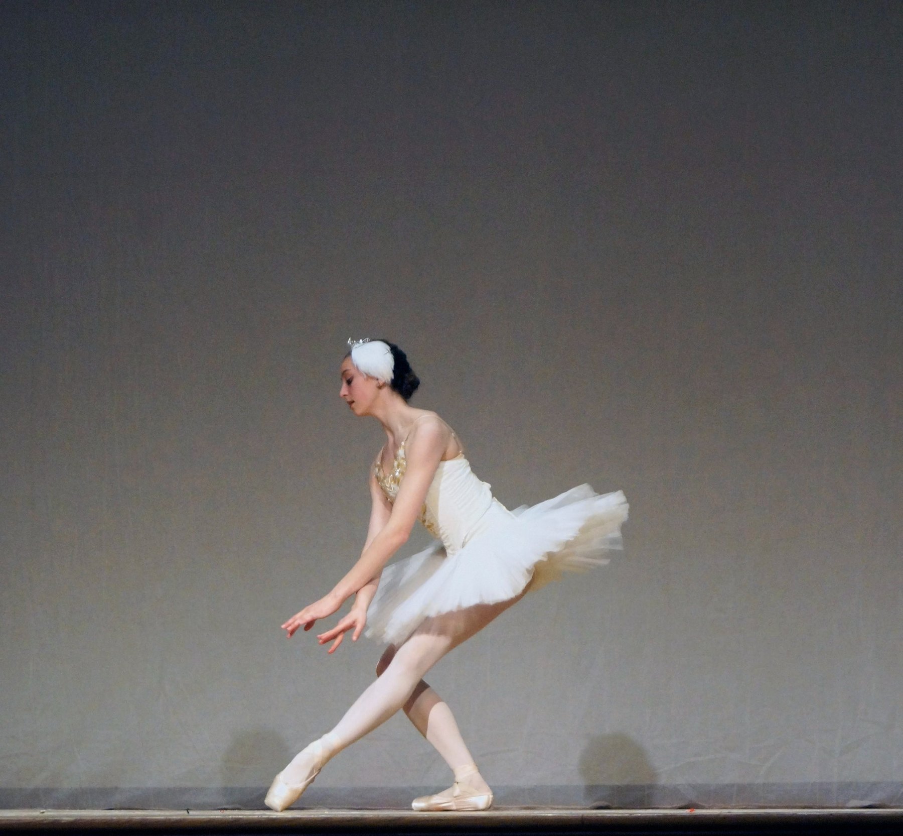 Ballet dancer in white classical tutu performing on stage