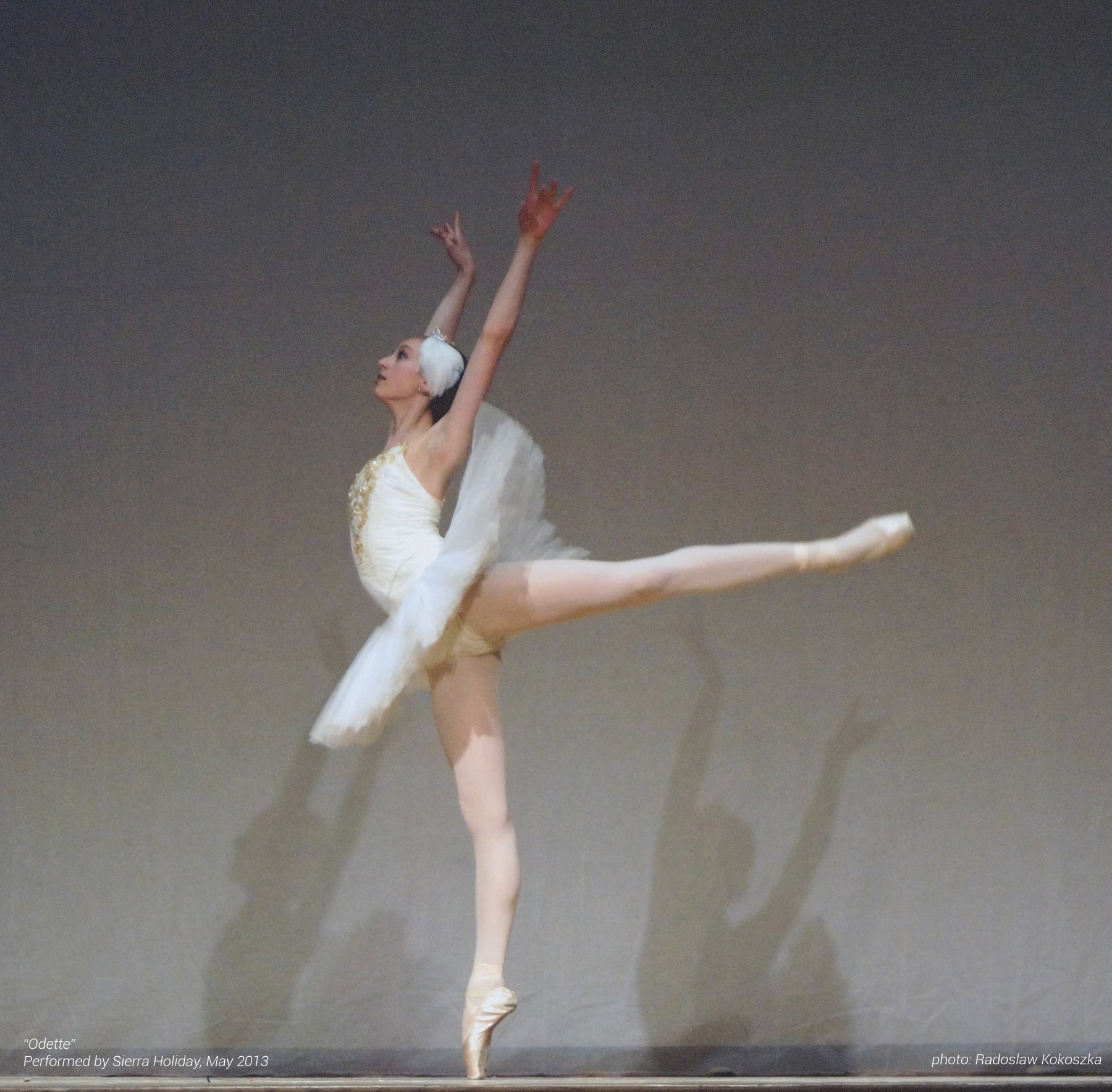Ballet dancer in arabesque wearing a white classical tutu